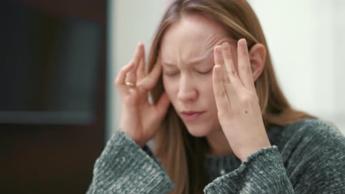 Woman Massaging Temples Experiencing Headache Pain