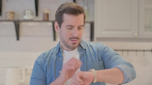 Man Checking Wristwatch Time Indoors in Kitchen