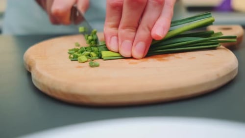 Cutting Green Onions with a Knife on a Cutting Board
