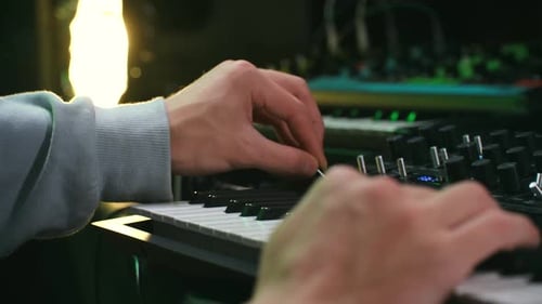 Hands Play Keyboard Synthesizer in Studio Environment