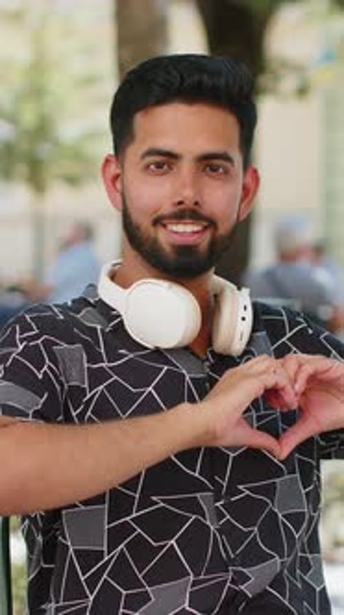 Young Man Making Heart Gesture Outdoors