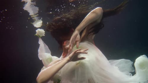 Woman in White Dress Underwater with Roses