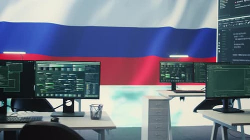Computer Monitors Showing Code in Office with Flag