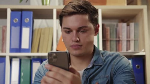 Young Man Using Phone Indoors Close Up