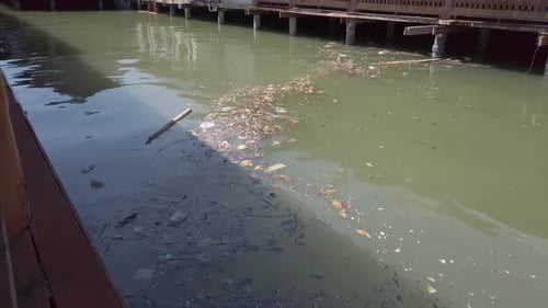 Polluted Urban Canal with Waste and Debris