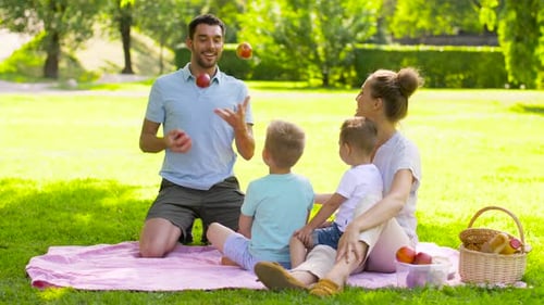 Family enjoying picnic on blanket in green park