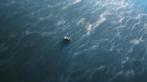Aerial drone vertical view of a man in a boat fishing on a river. Fog on the water