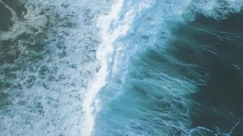 Birds eye view in 4k of a massive blue breaking wave in the stormy pacific ocean - Whitewater -Spray