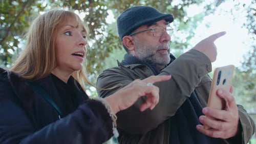 Mature Couple Using Mobile Phone in Park