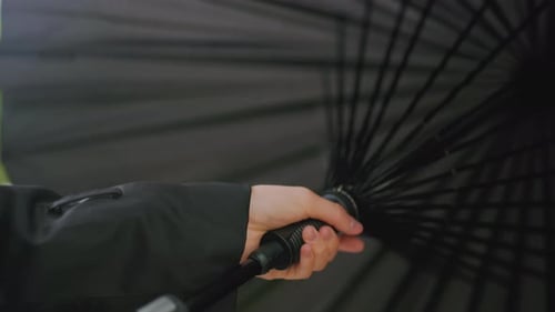 Close Up of Hand Holding Black Umbrella From Inside View