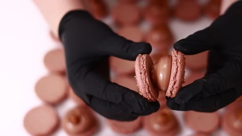 Gloved Hand Assembling Small Pink Macaron