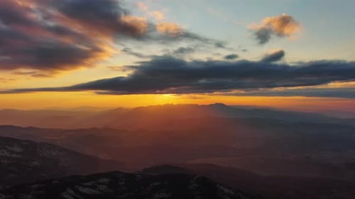 Orange Sunset Over Mountain with Dramatic Clouds