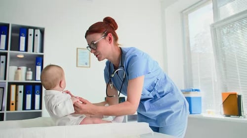 Infância Uma pediatra usando óculos com um estetoscópio examina uma criança pequena em um