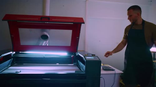 Techniker bereitet Lasergravurmaschine in der Werkstatt vor