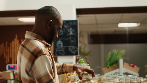 Male Customer Checking Types of Pasta or Grains at Local Market