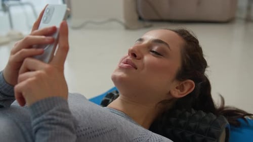 Young Woman Relaxing and Using Mobile Phone