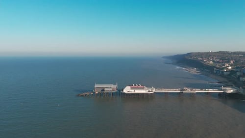 Aerial view of Cromer Pier in Norfolk stretching into the sea under a clear blue sky