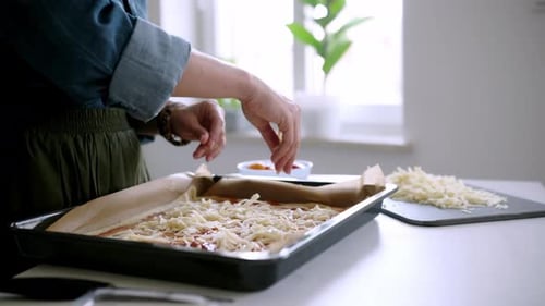 Woman Preparing Delicious Homemade Pizza in Bright Kitchen