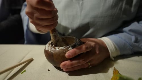 Adult Grinding Herbs with Pestle and Mortar