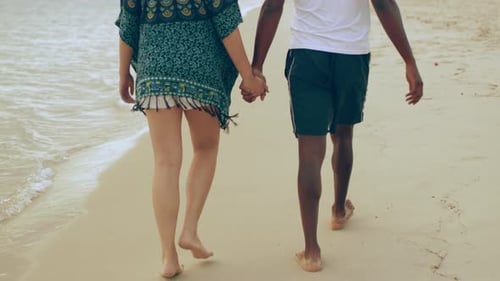 Young couple walking hand in hand on an australian beach enjoying each other