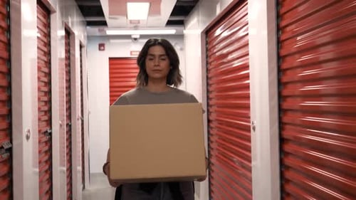 Une femme déplace ses affaires dans un casier de rangement