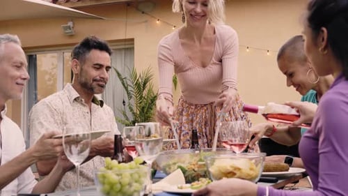 Pretty Smiling Middleaged Caucasian Woman Putting a Plate with Food on the Dining Table Serving
