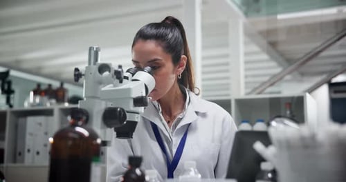Woman Scientist Using Microscope in Modern Lab