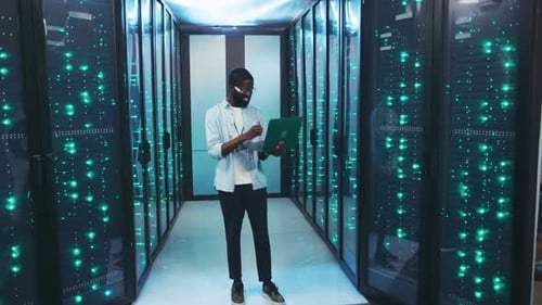 Man using laptop in a futuristic server room