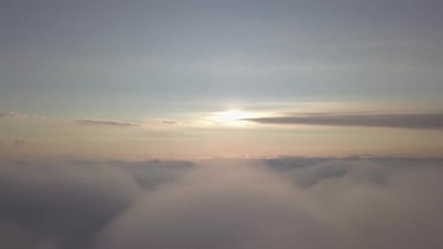 Aerial View of Sunrise Above Soft Clouds
