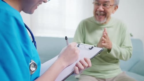 Friendly Nurse Consulting with Senior Patient Indoors