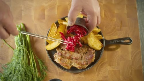 Top View of Professional Cook Stylishly Serving Steamed Frie Stake on a Plate