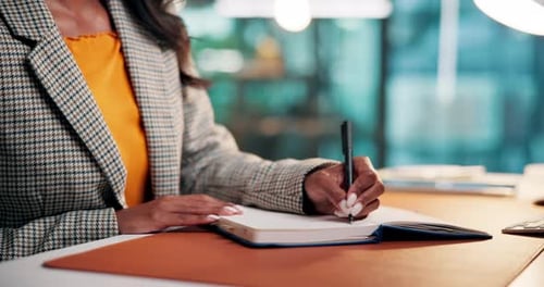 Woman Writes in Notebook at Desk