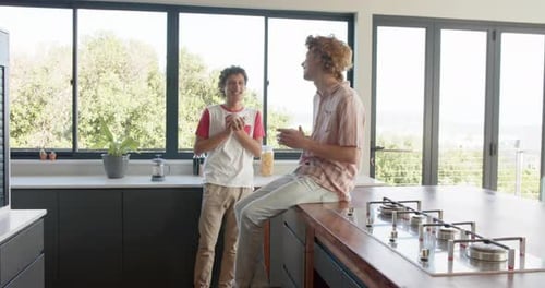 Two Young Men Chatting in Modern Kitchen