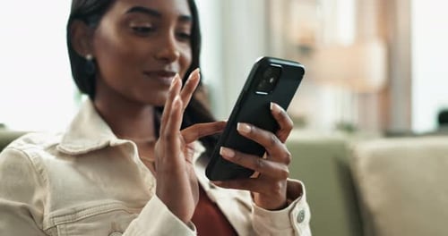 Indian woman, phone and scroll on couch at home, reading and typing on mobile application in lounge
