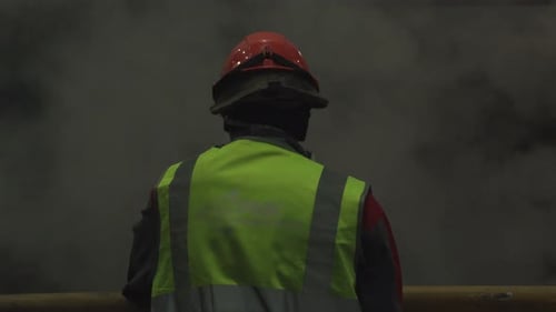 Construction Worker in Hard Hat Standing near Smoky Area