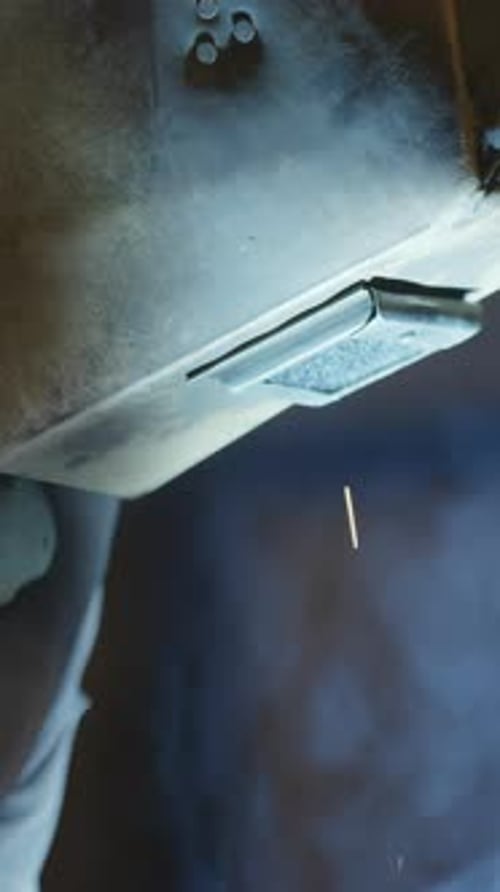 Sparks Flying During Welding Process in Dark Workshop