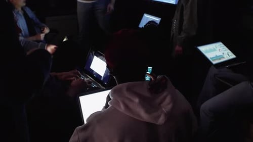 Hacker arbeiten während eines Hackathons im Dark Office 2529 Jahre an Laptops