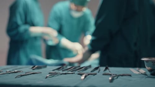 assistants and nurses performing invasive surgery on patient in hospital operating room.