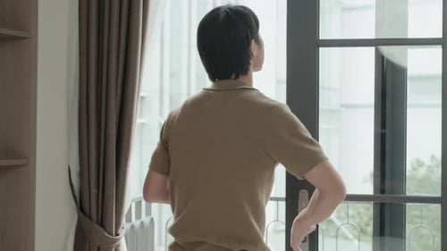 Young Adult Man Drinking Coffee by Window