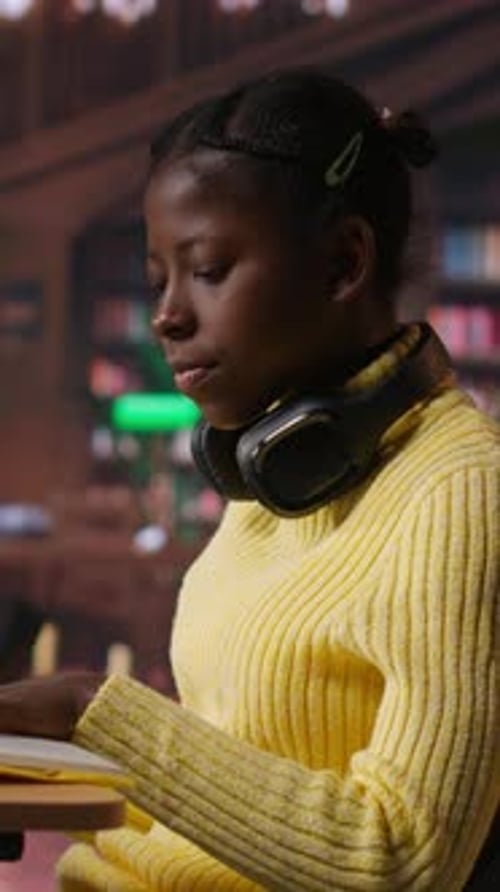 Vertical Video Teenage Girl at the Library Highlighting Relevant Phrases for Study Session