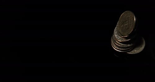 Vierteldollar-Münzen fallen, rollen und gleiten auf schwarzem Hintergrund, Zeitlupe 4K