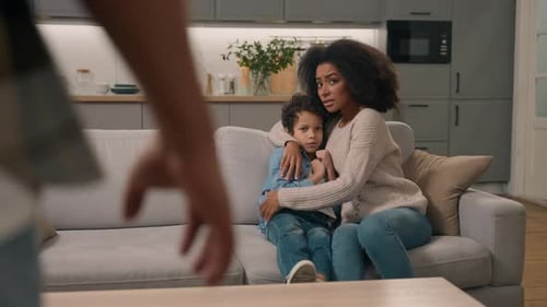 Mother and Child Sitting Frightened on Sofa