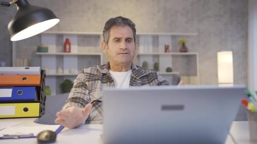 Mature man working in home office looking at laptop getting angry and aggressive.