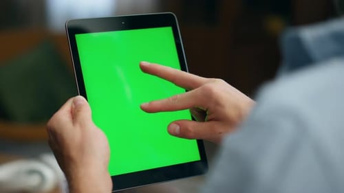 Man Using Tablet with Green Screen Indoors