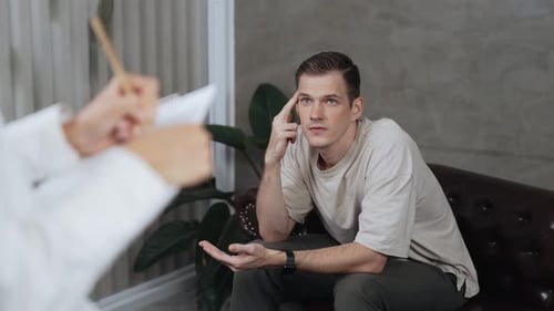 Concerned Man Talking with Therapist in Neutral Setting