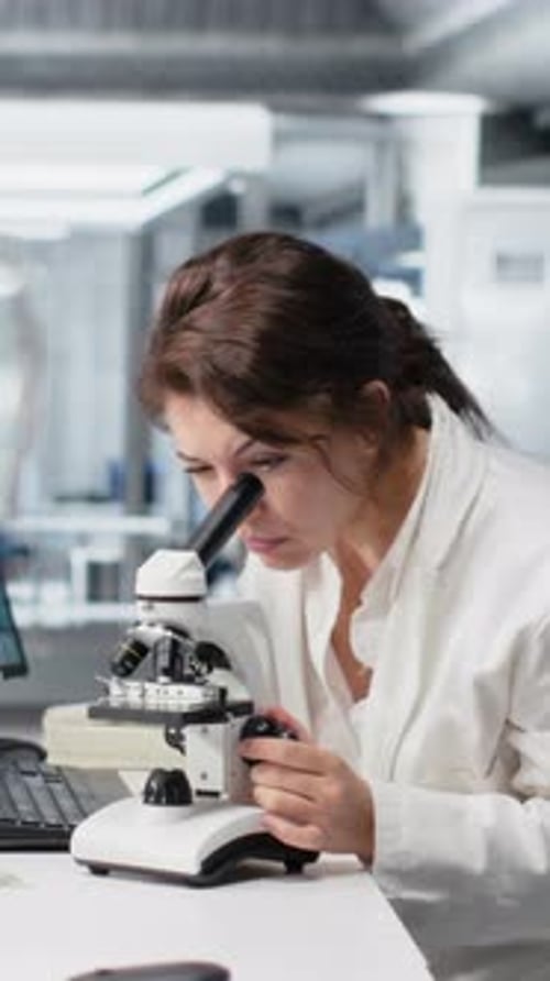 Vertical Video Materials Scientist Operating Compound Microscope Studying Genetic Disorders