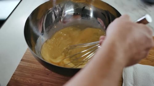 Nahaufnahme eines Mannes, Handkoch, der Lebensmittelzutaten in einer Stahlschüssel mischt. Baker Hands