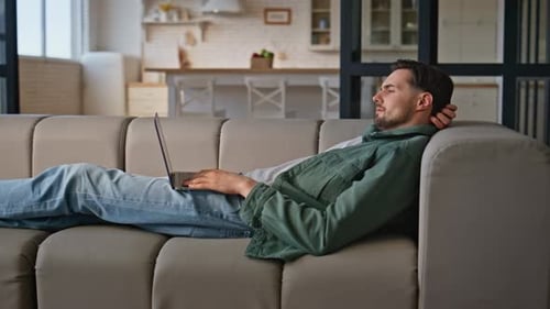 Chilling Freelancer Looking Computer Lying Beige Sofa Relaxed Man Working Couch