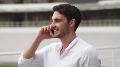 Confident businessman talking on cellphone in the city outdoors in slow motion