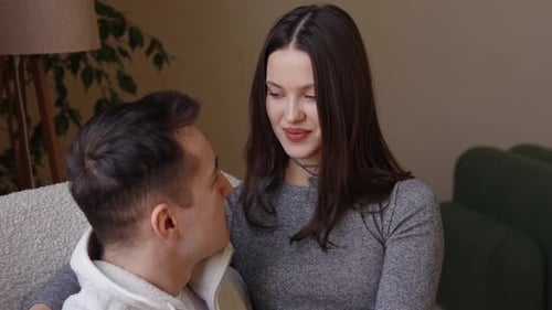 Loving Couple Kisses Intimately on Cozy Couch